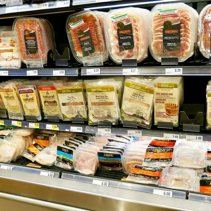 "Packaged deli meats on store shelf"