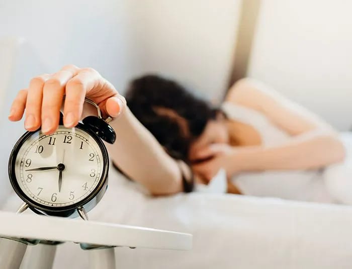 Person snoozing alarm clock.
