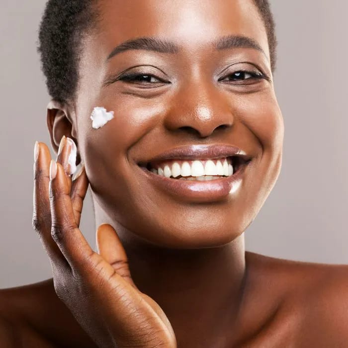 Woman moisturizing face.