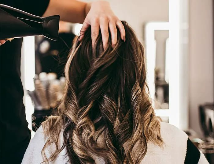Professional blowout using a hair dryer at the salon