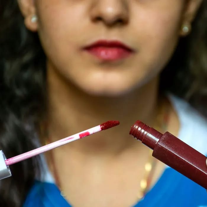 dark liquid matte lipstick brooding woman applicator plastic tube makeup cosmetic red product