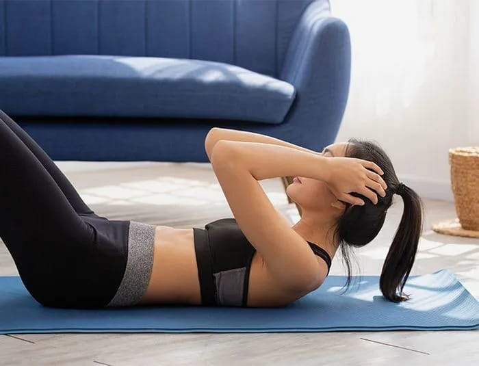 Woman in sportswear doing sit-ups