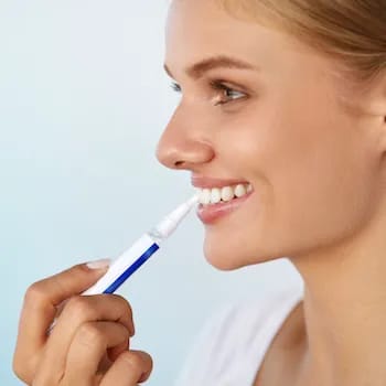 Dentist performing teeth whitening on a patient