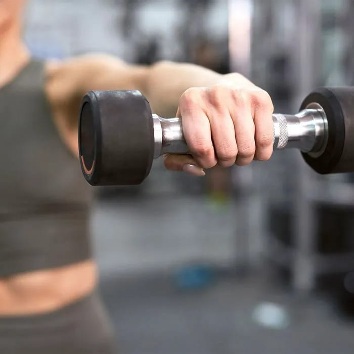 Woman strength training with dumbbell for muscle building