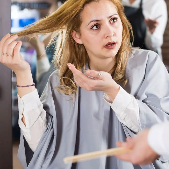 "Woman showing disappointment after a bad haircut at a salon"