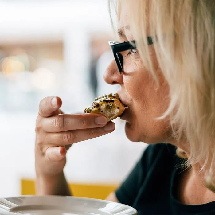 Blonde woman enjoying a donut for breakfast