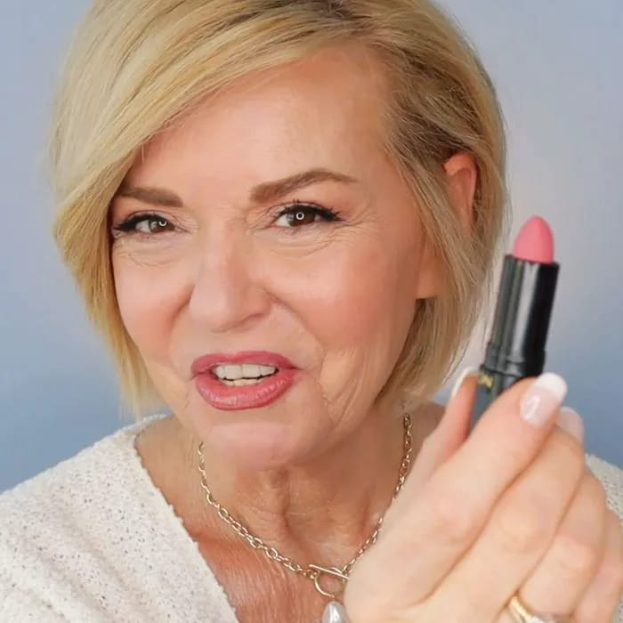 YouTuber applying lipstick for fuller lips tutorial.