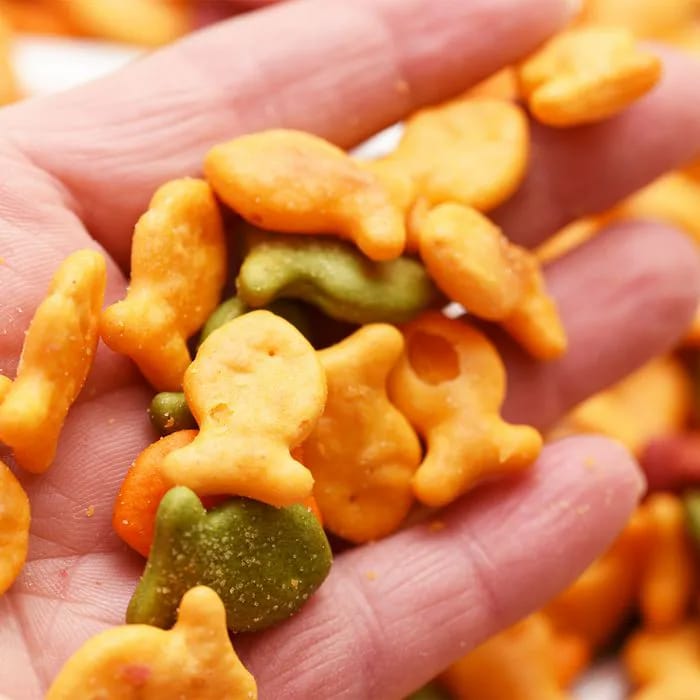 Hand holding a dozen colorful Goldfish snack crackers