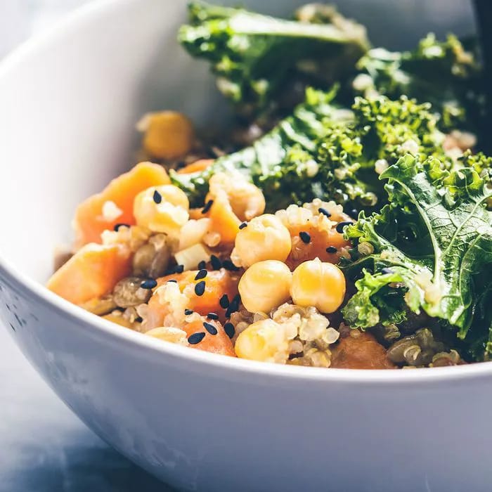 Bowl of chickpeas, lentils, quinoa, and kale for plant-based protein