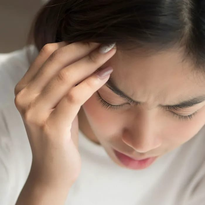 Young woman with headache or dizziness symptoms.