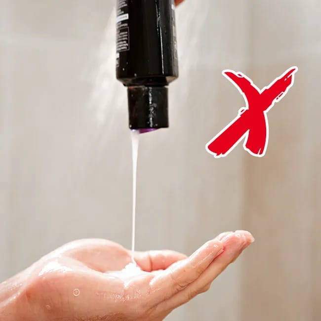 Pouring shampoo into a hand for application.
