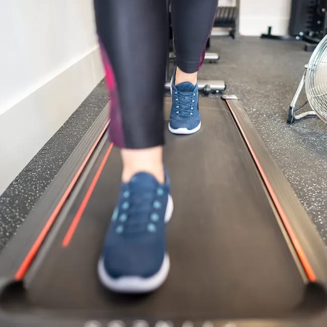 Woman walking on a treadmill for cardio workout.