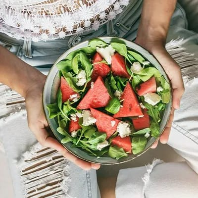Woman enjoying a fresh summer watermelon salad.