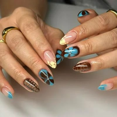 Colorful nails featuring brown, blue, and yellow designs.