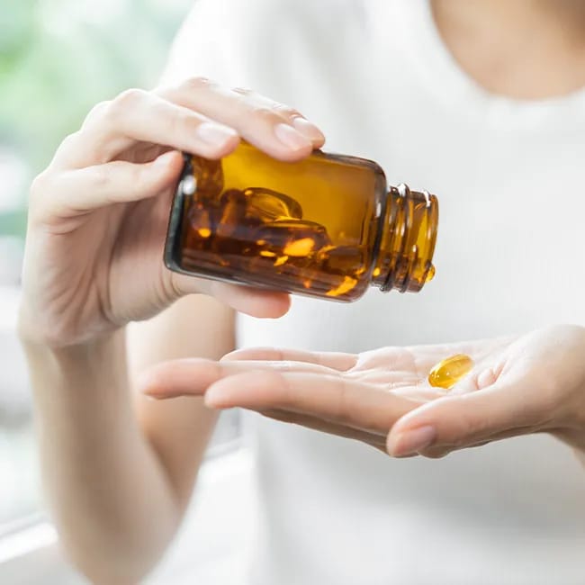 Pouring vitamin D drops into a palm