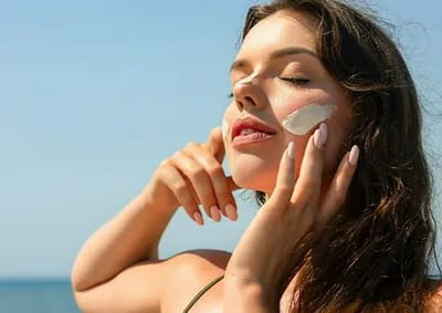 Woman applying sunscreen for sun protection.