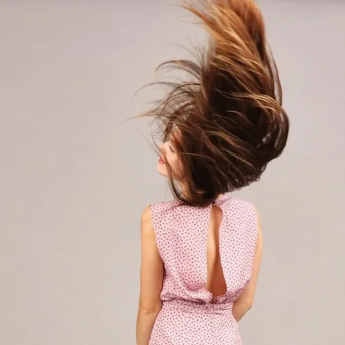 Woman flipping her hair, exuding confidence and beauty.