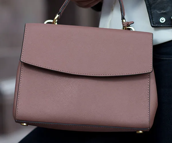 "Cleaning leather bag with a damp cloth"