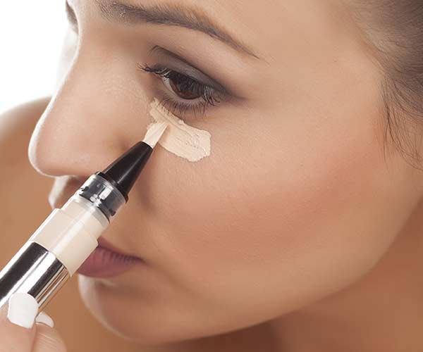 woman applying concealer