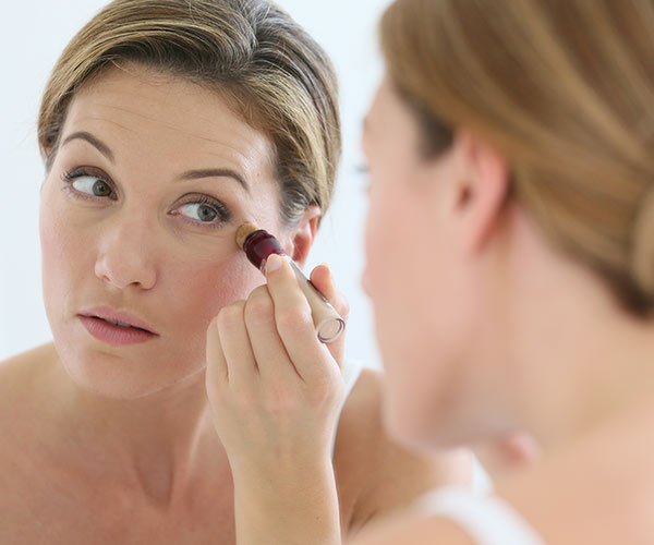 woman applying concealer