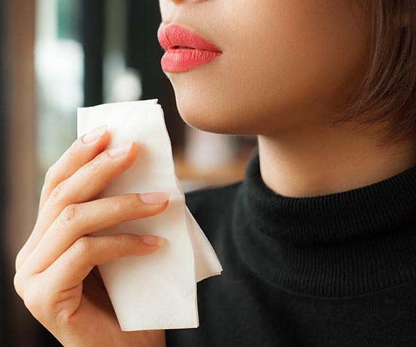 woman with red lips holding napkin