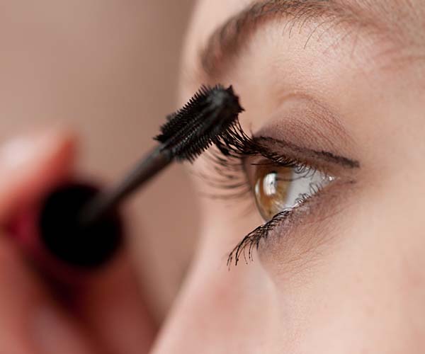 woman applying mascara to lashes