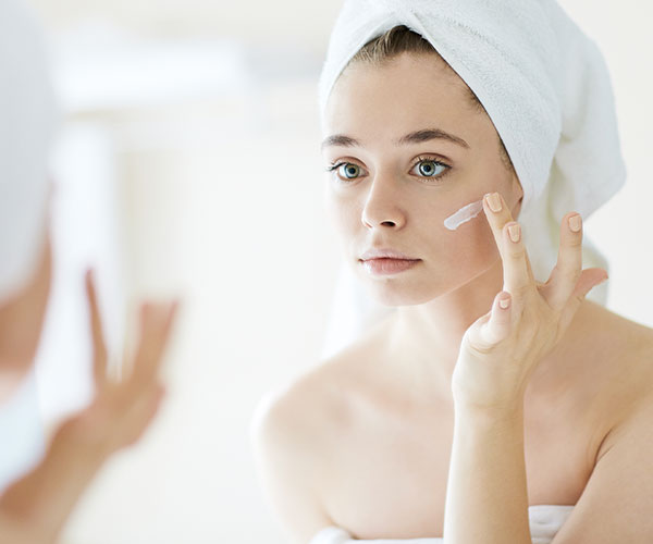 woman applying moisturizer