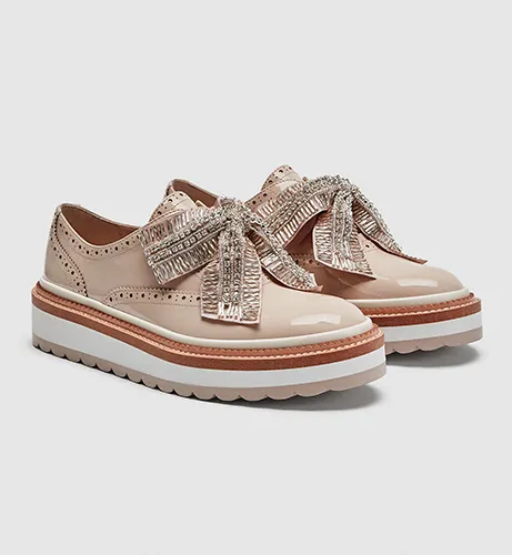 Elegant track sole brogues with bow detail for stylish footwear.