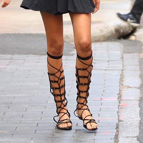 woman wearing knee-length strappy gladiators
