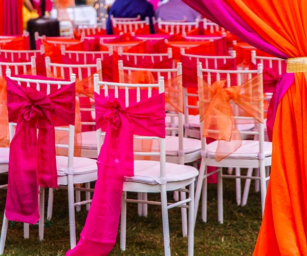 outdoor wedding chairs with neon and pastel ribbons