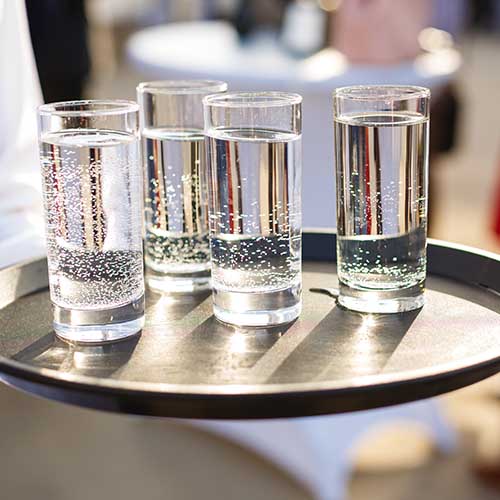 filled water glasses on serving tray