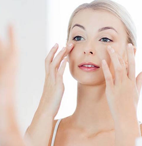 woman applying skincare products to face