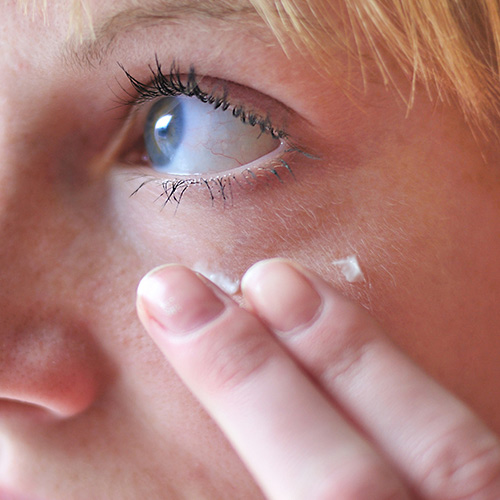 woman using eye cream