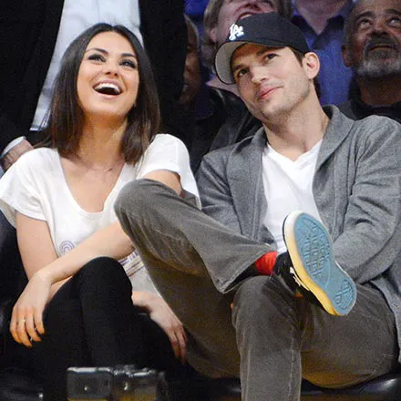 Ashton Kutcher and Mila Kunis smiling together.