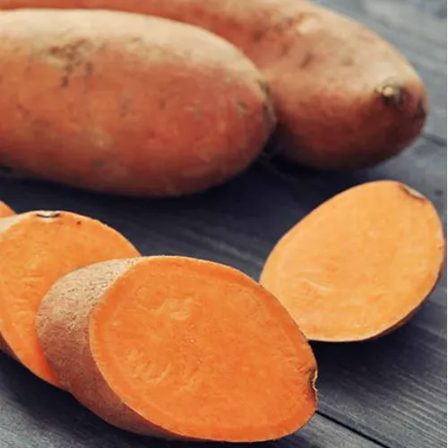 Roasted sweet potato served with greens on a plate