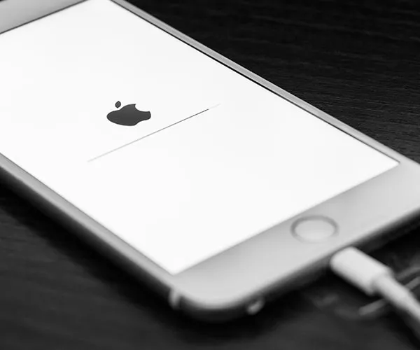 Stolen iPhone with a cracked screen lying on the ground.