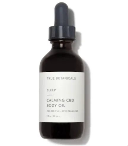 Close-up of True Botanicals facial oil surrounded by fresh greenery.