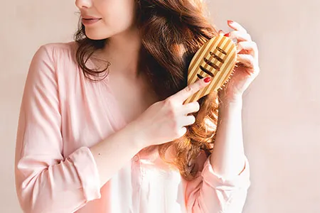 Woman brushing hair to the side for a stylish look.