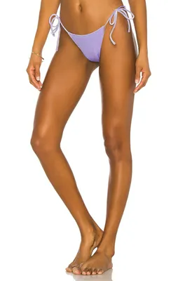 Chantel Jeffries wearing violet string bikini bottom by the pool.