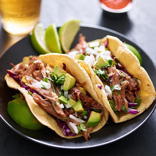 Pork carnitas tacos on a plate.