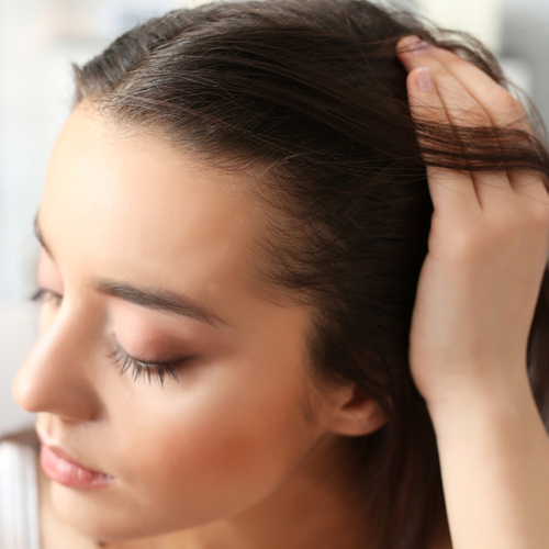 woman runs hands through hair