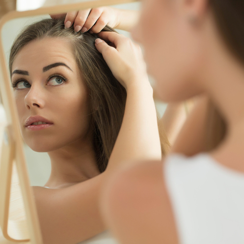 checking hair in mirror