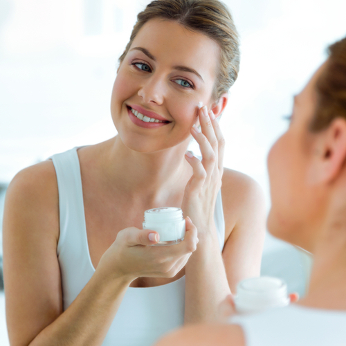 applying moisturizer in mirror