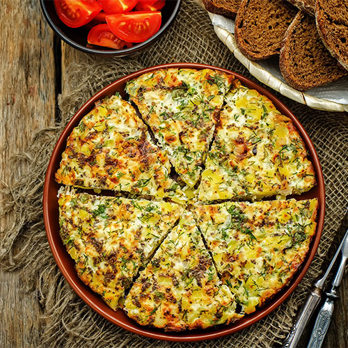 A frittata on a plate cut in wedges.