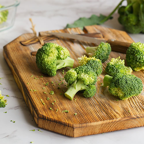 Broccoli florets on a wood board.