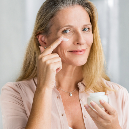 older woman applies eye cream