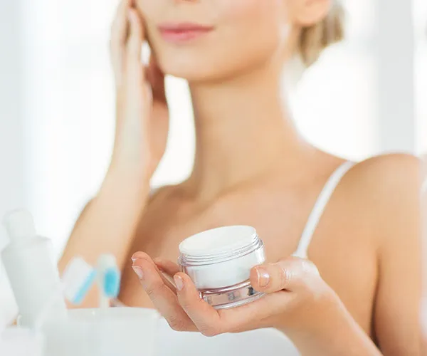 woman applying moisturizer