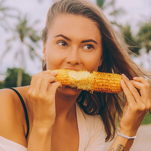 A woman eating corn on the cob.