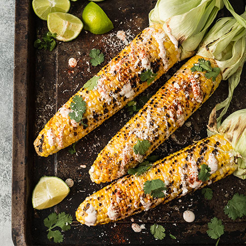 Grilled corn on a tray.