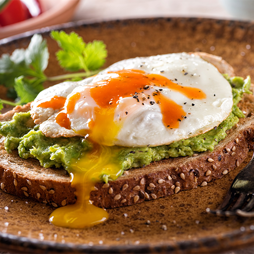 hot sauce and eggs on avocado toast